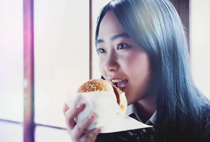 バーガーを食べる女性